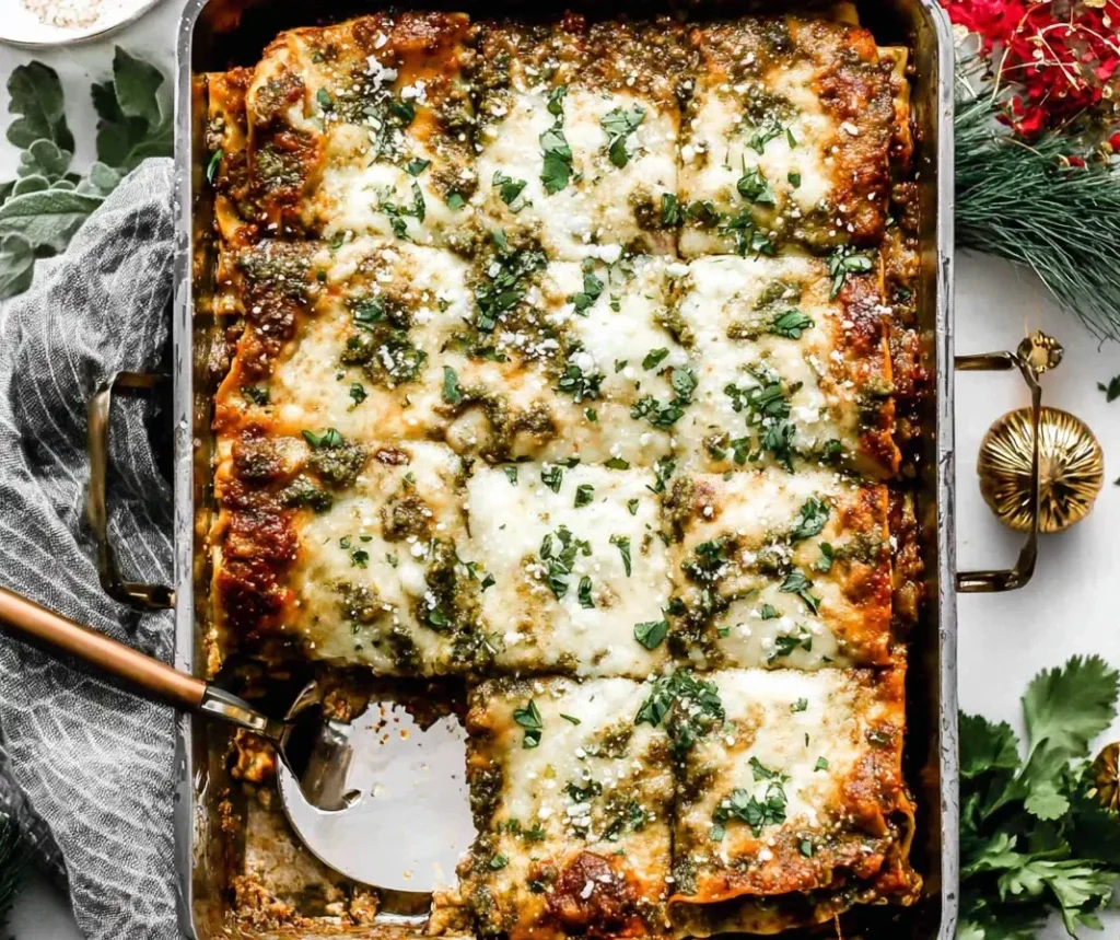 Golden-baked Christmas Eve Lasagna topped with melted cheese, pesto, and fresh herbs in a festive holiday setting.