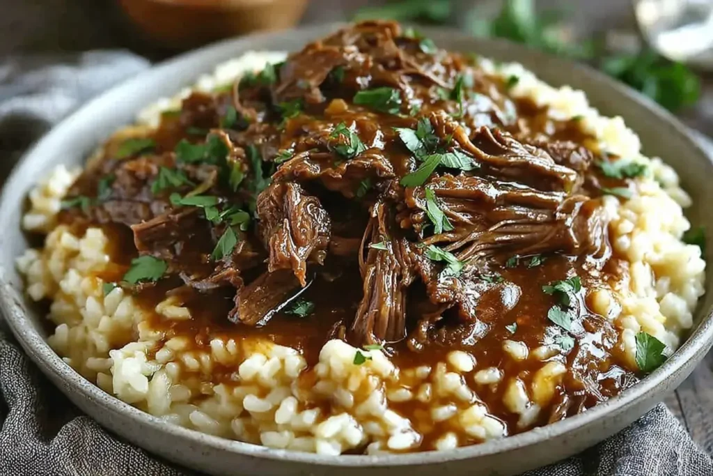 Slow Braised Pot Roast served over creamy Parmesan risotto, topped with rich tomato sauce and fresh parsley for the perfect comfort meal.