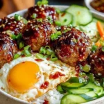 Korean BBQ Meatball Rice Bowls with glazed beef meatballs, fried egg, and fresh vegetables over white rice, topped with sesame seeds and green onions.
