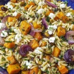 Fall Harvest Orzo Salad with roasted butternut squash, Brussels sprouts, red onions, and goat cheese tossed with orzo in a maple balsamic dressing.