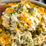 Crockpot Cheesy Chicken Broccoli Rice served with melted cheddar, tender chicken, and broccoli in a creamy slow-cooked casserole.