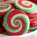 Sparkling Christmas Pinwheel Cookies with red and green swirls stacked on a plate.