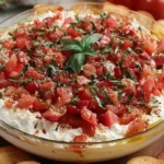 Bruschetta Dip topped with fresh diced tomatoes, basil, and creamy cheese served with toasted baguette slices.