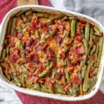 Crack Green Beans baked with crispy bacon and brown sugar glaze in a white casserole dish.