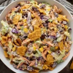 Colorful bowl of Frito Cowboy Cabbage salad with black beans, corn, and crunchy Fritos coated in creamy chipotle dressing.