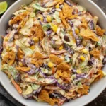 Close-up of creamy Frito Cowboy Cabbage salad with crunchy Fritos, black beans, corn, and colorful cabbage in a chipotle dressing.