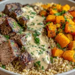 Butternut Squash and Garlic Herb Steak Bowls with roasted squash, juicy steak, grains, and creamy herb sauce, served in a hearty bowl.