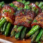 Crispy Bacon Wrapped Green Bean Bundles glazed with seasoning and roasted to perfection on a wooden board.