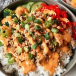 Bang Bang Ground Turkey Rice Bowls topped with creamy bang bang sauce, fresh vegetables, green onions, and sesame seeds over fluffy jasmine rice.