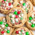 Santa’s Favorite Christmas Cookies loaded with red and green M&M’s, white chocolate chips, crushed peppermint, and melty chocolate chips on a baking tray.