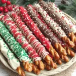 Christmas Pretzel Rods decorated with festive chocolate coatings and holiday sprinkles arranged on a platter.