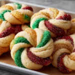 Twisted Christmas Cookies decorated with sparkling red, green, and gold sugar, arranged on a baking tray for a festive holiday treat.