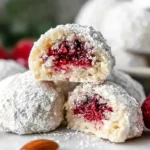 Raspberry Almond Snowball Cookies filled with raspberry jam and dusted with powdered sugar