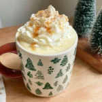 Christmas Chai Latte topped with whipped cream and caramel drizzle in a festive holiday mug.