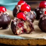 Rich chocolate-coated Cherry Bourbon Extract Balls topped with bright cherries and a soft, creamy center on a serving board.