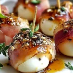 Prosciutto Wrapped Mozzarella Bites drizzled with olive oil and herbs, baked until crispy and served with toothpicks as a party appetizer.