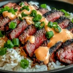 Korean BBQ Steak Rice Bowls topped with sliced grilled steak, fluffy white rice, green onions, and creamy spicy sauce.