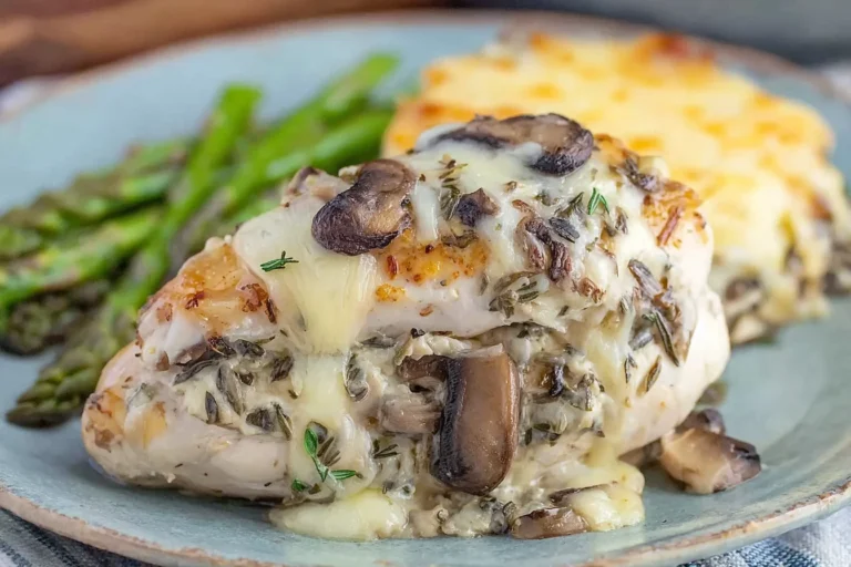 Gouda and Mushroom Stuffed Chicken breast with melted Gouda, sautéed mushrooms, and herbs, served with asparagus and a cheesy side dish.