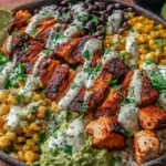 Chipotle Chicken Bowl with smoky grilled chicken, black beans, charred corn, rice, avocado, and creamy chipotle sauce, topped with cilantro and lime.