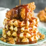 Southern Fried Chicken and Waffles stacked with crispy fried chicken and warm Belgian waffles, drizzled with spicy honey butter sauce.