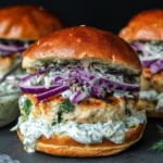 Greek Chicken Burgers with Tzatziki on a brioche bun topped with red onion and creamy herb tzatziki sauce.