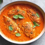 Mediterranean Chicken with Roasted Red Pepper Sauce in a skillet—creamy red pepper sauce over seared chicken, topped with fresh basil.