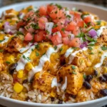 One Pot Cheesy Southwest Chicken and Rice topped with pico de gallo, black beans, corn, melted cheddar, and a creamy drizzle in a bowl.