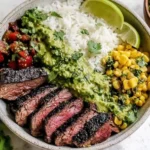 Cilantro Lime Steak Bowls with grilled sliced flank steak, fluffy white rice, charred corn, fresh salsa, creamy cilantro-lime sauce, and lime wedges.