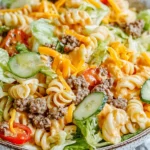 Big Mac Pasta Salad in a bowl with creamy special sauce, lean ground beef, cheddar, romaine, tomatoes, and pickles.