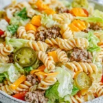 Big Mac Pasta Salad with rotini, lean ground beef, romaine, cheddar, tomatoes, and sliced pickles in creamy burger-style dressing.