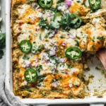 Salsa Verde Chicken Casserole topped with melted Monterey Jack, sliced jalapeños, cilantro, and diced red onion in a white baking dish.