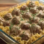 Swedish Meatball Noodle Bake in a glass casserole dish with egg noodles, creamy mushroom sauce, and tender meatballs topped with parsley.