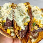 Street Corn Smash Burger Tacos folded and crispy, filled with juicy beef, charred corn, cotija cheese, and creamy jalapeño sauce