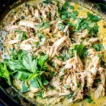 Slow Cooker Basil Chicken Coconut Curry in a crockpot with tender shredded chicken in creamy coconut curry sauce, topped with fresh basil and cilantro.