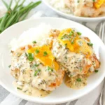 Chicken Olivia plated with creamy herb sauce and melted cheddar over tender chicken, garnished with chopped chives and served with white rice.