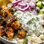 Mediterranean Lemon-Dill Chicken Bowls with charred lemon-herb chicken, creamy dill tzatziki, feta, cucumbers, cherry tomatoes, and red onion over a fresh bowl base.