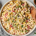 Mexican Macaroni Salad in a large bowl with creamy lime dressing, corn, black beans, tomatoes, cilantro, and jalapeño.