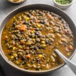 Protein Packed Black Bean and Lentil Soup in a bowl, thick and hearty with lentils, black beans, carrots, and veggies.