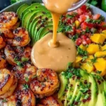 Shrimp and Avocado Bowls with Mango Salsa topped with creamy lime-chili sauce, charred shrimp, sliced avocado, and fresh mango salsa.