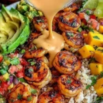 Shrimp and Avocado Bowls with Mango Salsa with grilled chili shrimp, sliced avocado, mango chunks, and lime-chili sauce drizzled over rice.