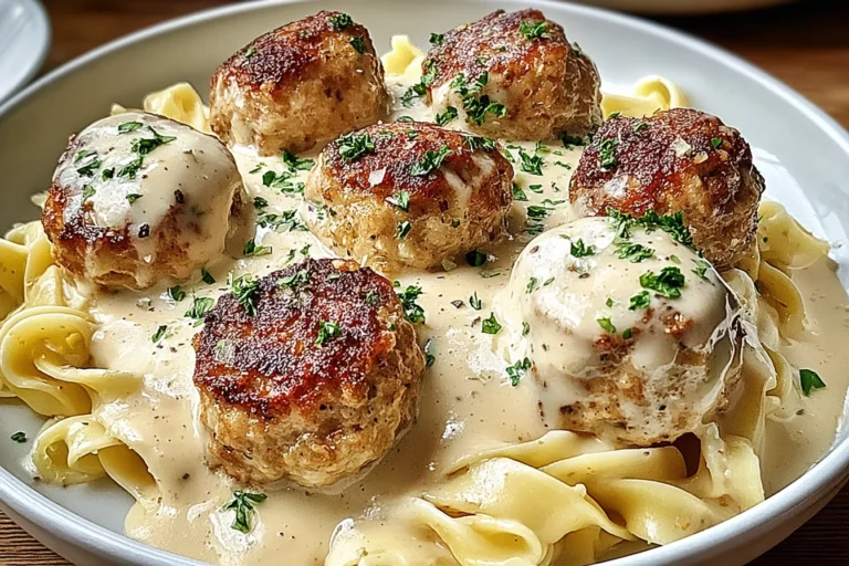 Chicken Cordon Bleu Meatballs over egg noodles with creamy Dijon sauce, topped with parsley and golden-browned crust.