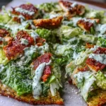 Chicken Crust Caesar Salad Pizza topped with crisp romaine, Parmesan, and creamy Caesar dressing on a golden chicken crust