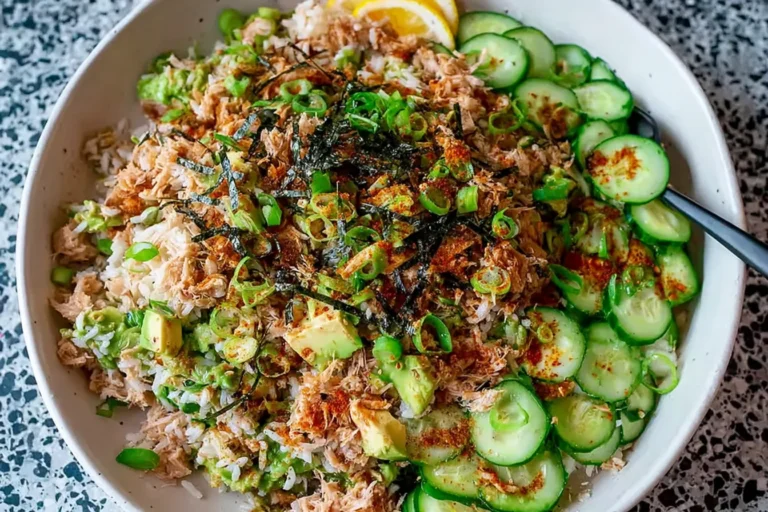 Tuna Avocado Crispy Rice Salad in a bowl with cucumber slices, flaky tuna, diced avocado, scallions, and seaweed on rice