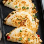Healthy Baked Chicken Quesadilla baked until golden and crispy on a sheet pan, filled with shredded chicken, peppers, and melted cheese.