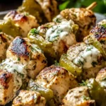 Dill Pickle Ranch Chicken Skewers grilled until juicy with charred edges, topped with creamy ranch and fresh dill on a serving plate.