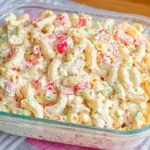 Cheddar Sour Cream Macaroni Salad in a glass dish, creamy pasta salad with crunchy celery, red pepper, and herbs.