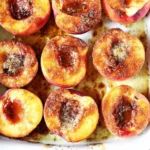 Cinnamon Sugar Baked Peaches baking in a white dish, sprinkled with brown sugar and warm spices until golden and bubbly.