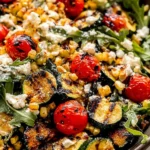 Grilled Zucchini Salad, up close and crave-worthy—charred zucchini, sweet corn, blistered tomatoes, peppery arugula, and creamy goat cheese.