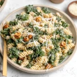 Kale Caesar Pasta Salad in a shallow bowl with rotini, massaged kale, crispy chickpeas, and grated parmesan.