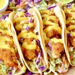 Honey Mustard Chicken Tacos loaded with crispy breaded chicken, crunchy cabbage slaw, and a rich honey mustard drizzle in warm tortillas.